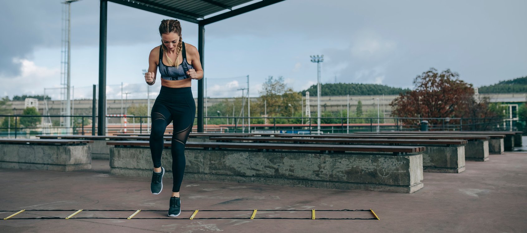 Young Fit Woman Jumping on an Agility Ladder