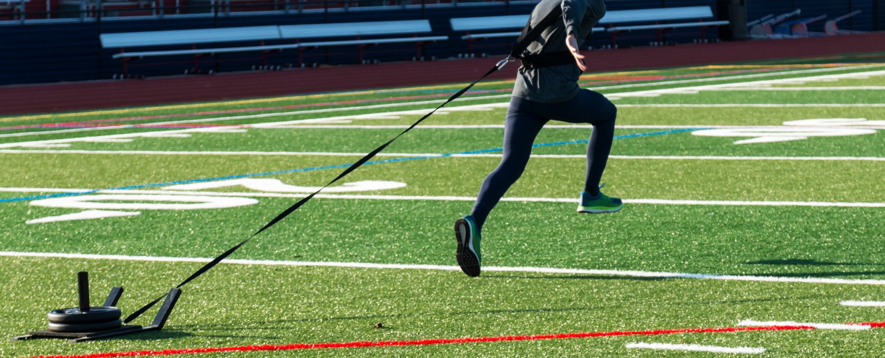 Runner sprinting pulling a weght sled