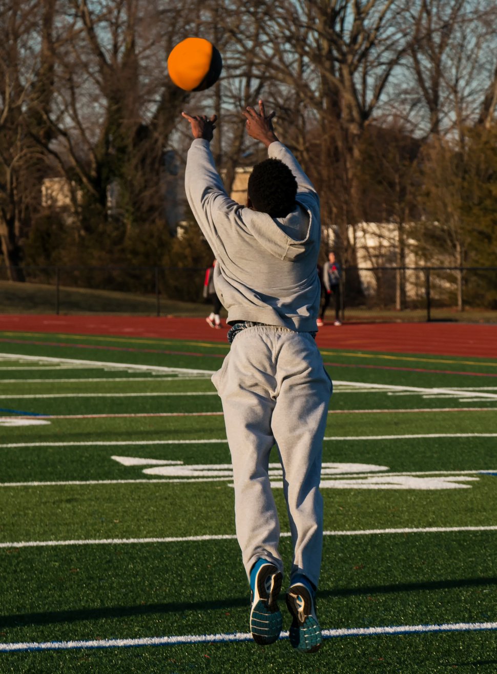 Athlete throwing a medicine ball foward and jumping